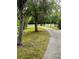 Scenic community view of a driveway bordered by trees and a white fence at 10852 Spider Lily Dr # S, Orlando, FL 32832