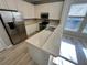 Kitchen featuring stainless steel appliances, white cabinets, marble countertops, breakfast bar and wood flooring at 10852 Spider Lily Dr # S, Orlando, FL 32832
