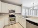 Bright kitchen featuring stainless steel appliances, white cabinets, updated countertops, and modern fixtures at 10852 Spider Lily Dr # S, Orlando, FL 32832