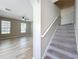 Well-lit living space flowing to carpeted stairs and featuring wood-look floors at 10852 Spider Lily Dr # S, Orlando, FL 32832
