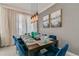Dining room featuring a modern dining table set with blue chairs and stylish pendant lighting at 1188 Challenge Dr, Davenport, FL 33896
