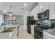 Modern kitchen design with stainless steel appliances, gray backsplash, and an island with a sink at 1188 Challenge Dr, Davenport, FL 33896
