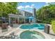 The backyard oasis has a freeform pool and hot tub next to a covered patio, and the well-maintained home is on the right at 1311 Olympia Park Cir, Ocoee, FL 34761