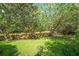 Landscaped backyard featuring mature trees and a wooden privacy fence at 1311 Olympia Park Cir, Ocoee, FL 34761