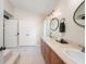 Bathroom featuring double sinks with tan counters, light wood cabinets and modern lighting at 1311 Olympia Park Cir, Ocoee, FL 34761