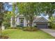 Charming two-story home with a lush front lawn, mature trees, and a neatly manicured landscape at 1311 Olympia Park Cir, Ocoee, FL 34761