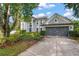 Beautiful home with an attached two-car garage, mature trees, and a welcoming facade at 1311 Olympia Park Cir, Ocoee, FL 34761