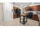 Well-lit kitchen with stainless steel appliances, wooden cabinets, and center island with tile flooring at 1311 Olympia Park Cir, Ocoee, FL 34761