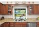 Kitchen sink overlooks outdoor pool and landscaped backyard with granite counters and stainless steel appliances at 1311 Olympia Park Cir, Ocoee, FL 34761