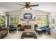 Bright living room features a fireplace, tile flooring, a ceiling fan, and large windows overlooking the backyard at 1311 Olympia Park Cir, Ocoee, FL 34761