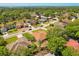 Aerial view of a residential neighborhood with lush green trees and a lake in the distance at 1330 Broken Pine Rd, Deltona, FL 32725