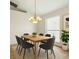 Bright dining room featuring a modern light fixture and six chairs around a wooden table at 1330 Broken Pine Rd, Deltona, FL 32725