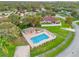 Aerial view of the pool and clubhouse, surrounded by lush green grass and mature trees at 1330 Broken Pine Rd, Deltona, FL 32725