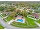 Aerial view of a community pool with fencing and a covered area, surrounded by lush green lawns and mature trees at 1330 Broken Pine Rd, Deltona, FL 32725