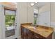 Bathroom featuring double granite vanity and access to outdoor balcony at 1417 Olympia Ave, Mount Dora, FL 32757