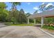 Exterior view of a porte cochere and circular driveway bordered with a garden at 1417 Olympia Ave, Mount Dora, FL 32757