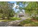 View of home exterior showing the driveway, porte cochere and mature landscaping at 1417 Olympia Ave, Mount Dora, FL 32757