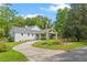 Landscaped exterior with a porte cochere, gray roof, and a winding driveway at 1417 Olympia Ave, Mount Dora, FL 32757