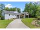 Exterior showing porte cochere, lovely landscaping, driveway, and craftsman-style details at 1417 Olympia Ave, Mount Dora, FL 32757