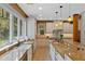 Well-lit kitchen showcasing custom cabinetry, granite countertops and stainless steel appliances at 1417 Olympia Ave, Mount Dora, FL 32757