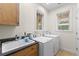 Laundry room features a utility sink, countertop, two windows and a washer and dryer at 1417 Olympia Ave, Mount Dora, FL 32757