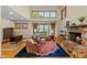 Bright living room featuring a stone fireplace, and large windows providing plenty of natural light at 1417 Olympia Ave, Mount Dora, FL 32757