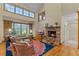 Cozy living room with a stone fireplace, large windows, and hardwood floors at 1417 Olympia Ave, Mount Dora, FL 32757