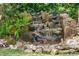 Detailed view of the backyard stone water feature with lush fern accents at 1417 Olympia Ave, Mount Dora, FL 32757