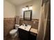 A bathroom featuring a toilet, vanity, and textured wall with earth tones at 1433 Kingston Ave, Orlando, FL 32807