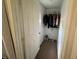 A walk-in closet with hanging clothes and shoes on the floor at 1433 Kingston Ave, Orlando, FL 32807