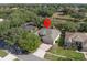 Aerial view of this home featuring a paved driveway, well-maintained lawn, and mature trees at 1551 Sherbrook Dr, Clermont, FL 34711