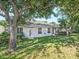 Back exterior view of home with trees and well-maintained landscaping at 1551 Sherbrook Dr, Clermont, FL 34711
