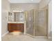 Bright bathroom with granite counters, undermount sink, framed mirror, and glass shower enclosure at 1551 Sherbrook Dr, Clermont, FL 34711