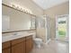 Bathroom with vanity, granite counter, white toilet, and glass shower enclosure by patio door at 1551 Sherbrook Dr, Clermont, FL 34711