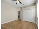 Bedroom with a ceiling fan, closet, and wood floors, with a bathroom visible through open doorway at 1551 Sherbrook Dr, Clermont, FL 34711
