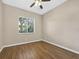Bedroom with ceiling fan, wood floors, and window with mini blinds with a view of landscaping at 1551 Sherbrook Dr, Clermont, FL 34711