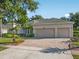 Well-maintained home with a three-car garage and a brick-paved driveway surrounded by mature trees at 1551 Sherbrook Dr, Clermont, FL 34711