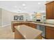 Spacious kitchen features a center island, a view of the fireplace, and ample cabinet space at 1551 Sherbrook Dr, Clermont, FL 34711