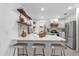 Bright kitchen boasts a large island with seating, modern appliances, and stylish open shelving at 1558 Regal Oak Dr, Kissimmee, FL 34744