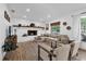 Bright living room with a white brick fireplace, mantle, and new wood flooring at 1558 Regal Oak Dr, Kissimmee, FL 34744