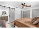 Comfortable main bedroom featuring a barn door to the bathroom, neutral color palette, and modern ceiling fan at 1558 Regal Oak Dr, Kissimmee, FL 34744