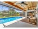 Inviting screened-in pool area with outdoor seating, a ceiling fan, and lush landscaping in the backyard at 1558 Regal Oak Dr, Kissimmee, FL 34744