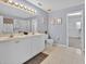 Well lit bathroom featuring double vanity, tile floors, and a bright and airy atmosphere at 16844 Rising Star Dr, Clermont, FL 34714