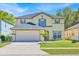 Charming two-story home with a two-car garage, lush lawn, and well-maintained landscaping at 16844 Rising Star Dr, Clermont, FL 34714