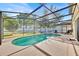 A sparkling pool with a screened enclosure, patio, and lush greenery surrounds this backyard oasis at 16844 Rising Star Dr, Clermont, FL 34714