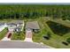 Aerial view of a home showcasing the landscape, pond, and brick driveway nestled amongst lush greenery at 17309 Cagan Crossing Blvd, Clermont, FL 34714