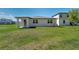 A spacious green backyard with a covered patio, a well-maintained lawn, and a view of the house at 17309 Cagan Crossing Blvd, Clermont, FL 34714