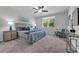 Bedroom with soft carpet, ceiling fan, and ensuite bathroom view, creating a cozy retreat at 17309 Cagan Crossing Blvd, Clermont, FL 34714