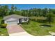 Charming single-story home with a well-manicured lawn, pond view, and brick driveway at 17309 Cagan Crossing Blvd, Clermont, FL 34714