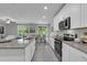 Modern kitchen with granite countertops and stainless steel appliances that flows into the living spaces at 17309 Cagan Crossing Blvd, Clermont, FL 34714